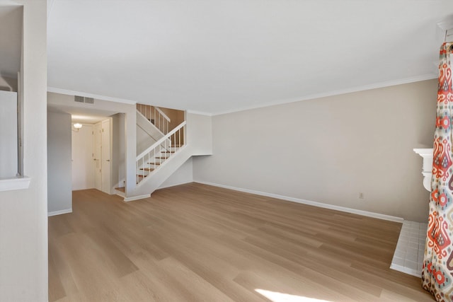 unfurnished living room featuring visible vents, stairway, baseboards, and wood finished floors