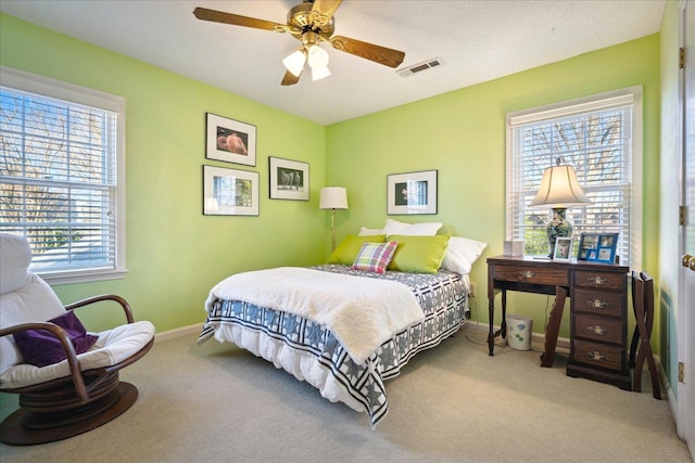 bedroom with baseboards, visible vents, ceiling fan, and light colored carpet