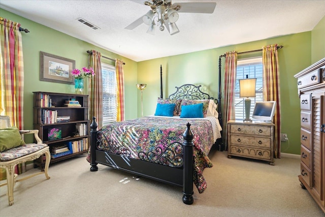 bedroom with light carpet, multiple windows, visible vents, and a textured ceiling