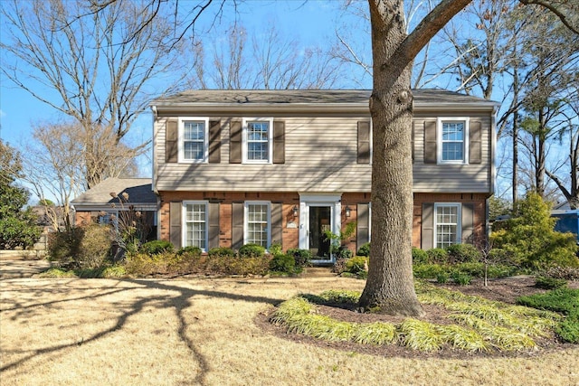 colonial house featuring brick siding