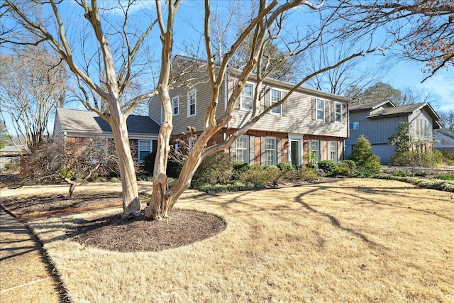 colonial house with a front yard and brick siding