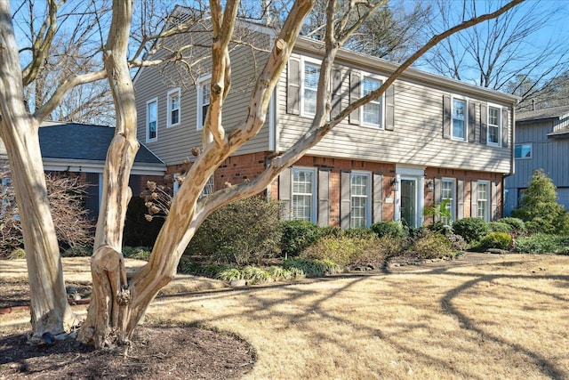 view of front of house with brick siding and a front lawn