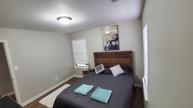 bedroom featuring dark wood-style flooring and baseboards