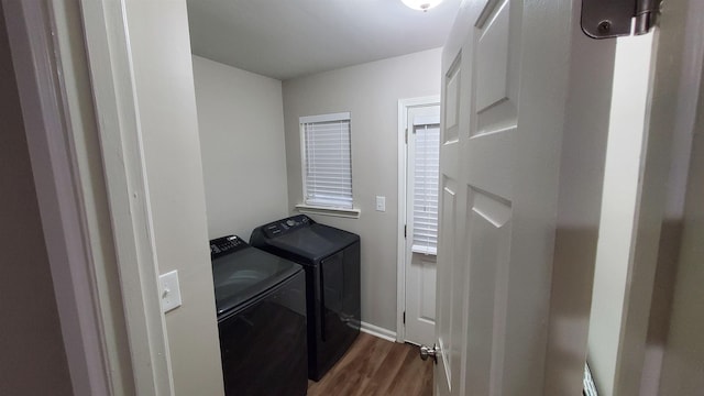 washroom featuring laundry area, separate washer and dryer, dark wood-style flooring, and baseboards