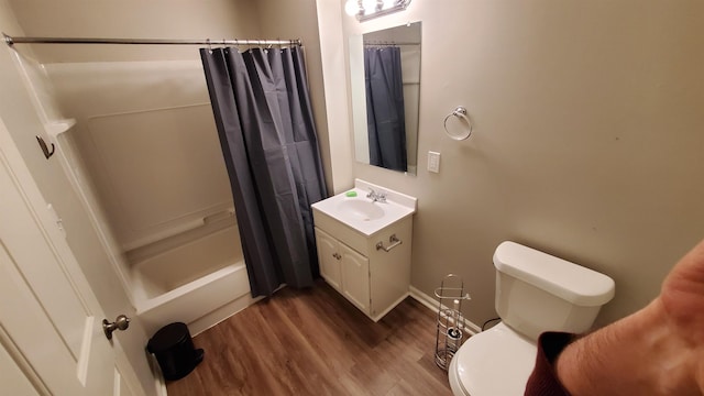 full bathroom with shower / tub combo, baseboards, toilet, wood finished floors, and vanity