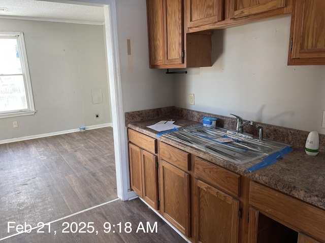 kitchen with dark wood-type flooring, a sink, and brown cabinets