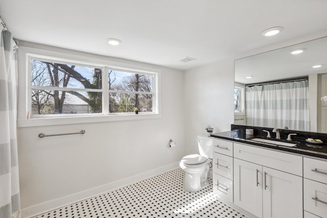 bathroom with plenty of natural light, vanity, visible vents, and baseboards