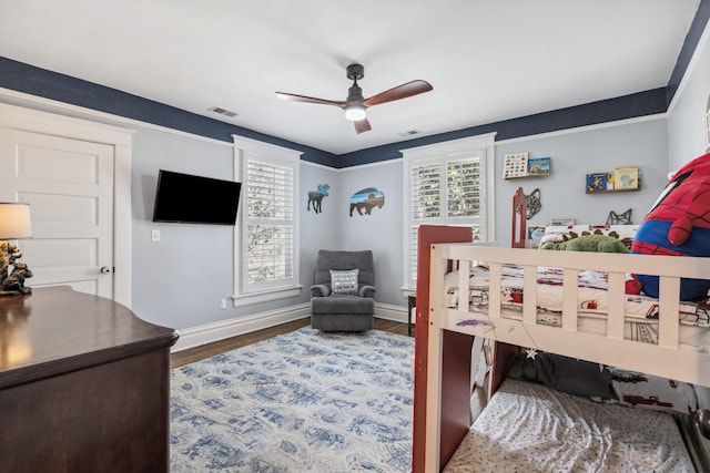 bedroom with visible vents, wood finished floors, a ceiling fan, and baseboards