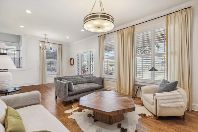 living room with baseboards, ornamental molding, wood finished floors, and recessed lighting