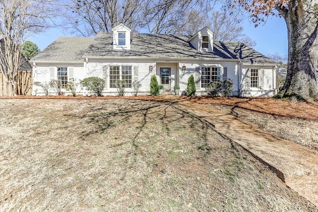 new england style home with a shingled roof