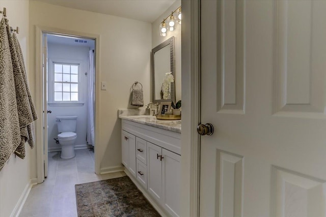 full bath featuring toilet, visible vents, vanity, and baseboards