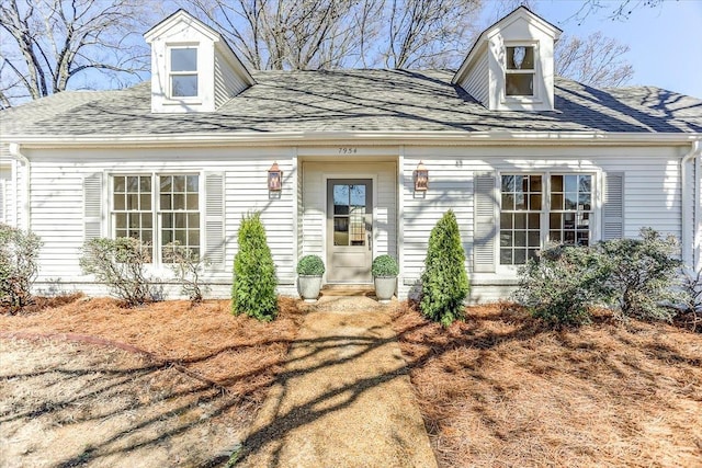 new england style home with a shingled roof