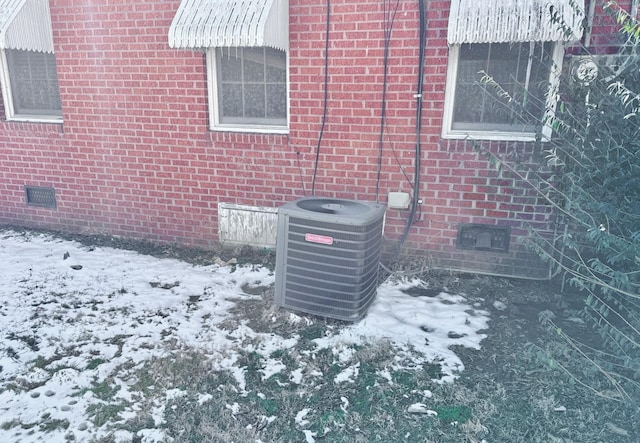 details with crawl space, central air condition unit, and brick siding