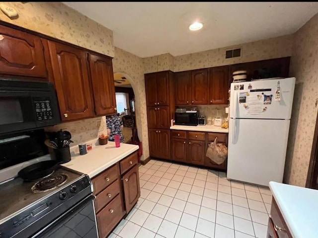 kitchen featuring black appliances, visible vents, light countertops, and wallpapered walls