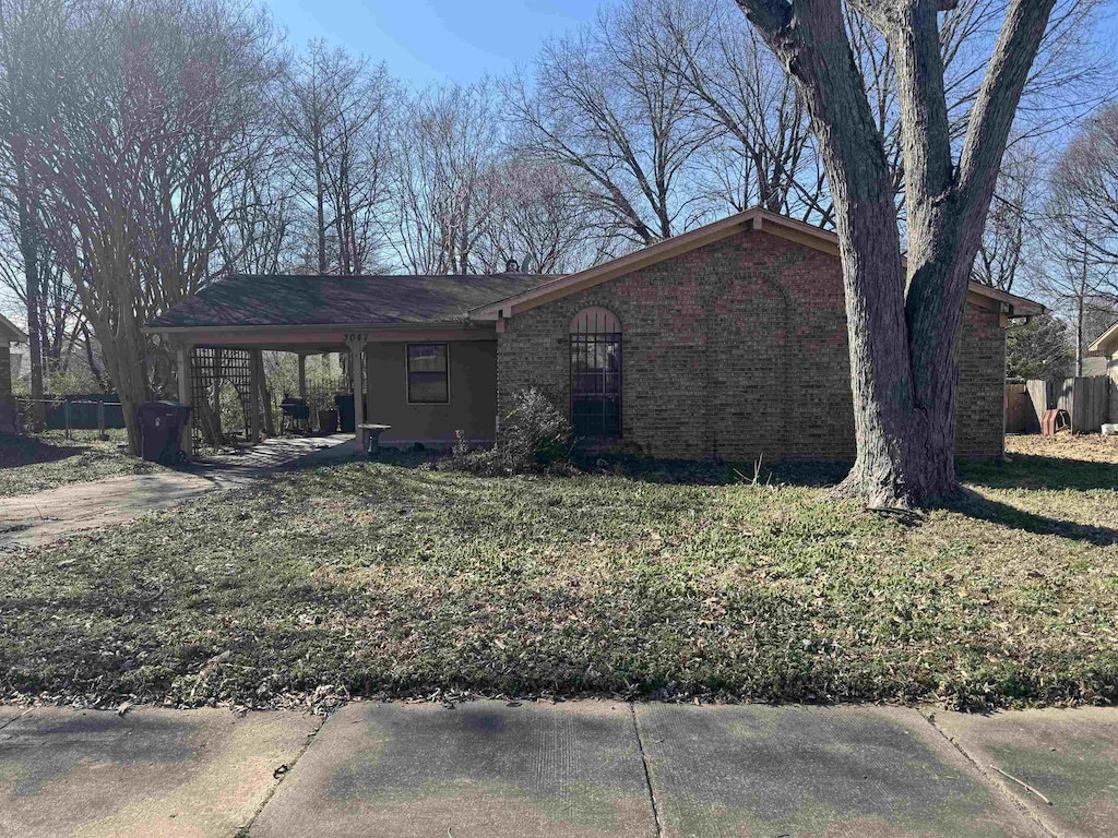 view of front facade with a front yard and brick siding