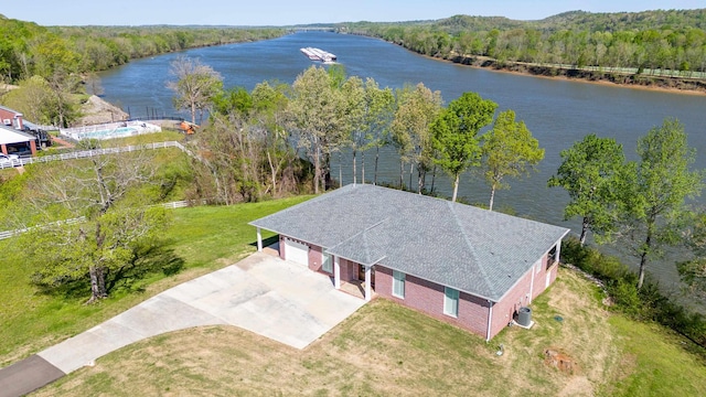 birds eye view of property featuring a water view and a wooded view