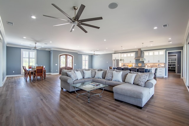 living area with recessed lighting, dark wood-style flooring, visible vents, baseboards, and crown molding