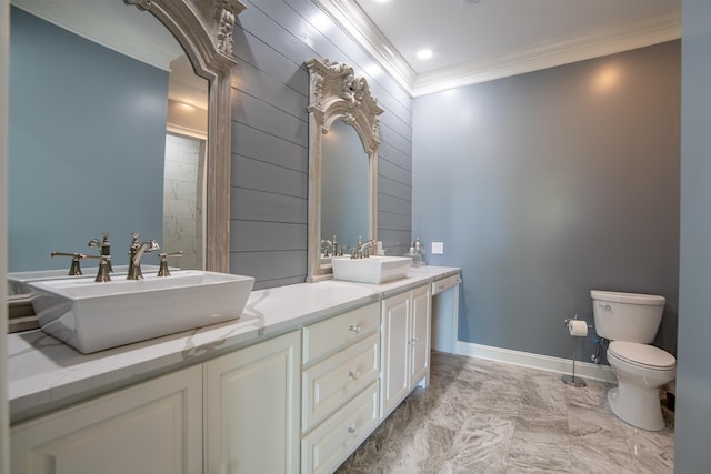 full bathroom featuring double vanity, toilet, marble finish floor, crown molding, and a sink