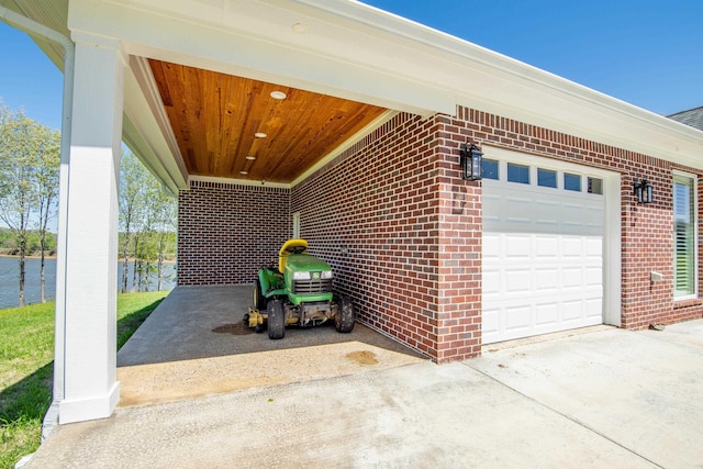 garage with a carport and concrete driveway