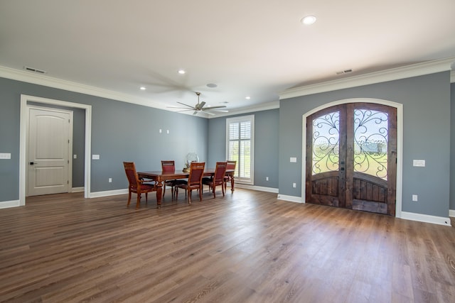 dining room with baseboards, visible vents, wood finished floors, crown molding, and french doors