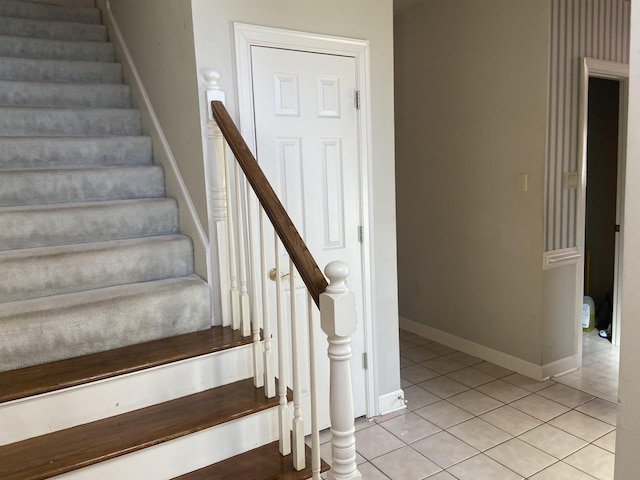 stairs featuring baseboards and tile patterned floors