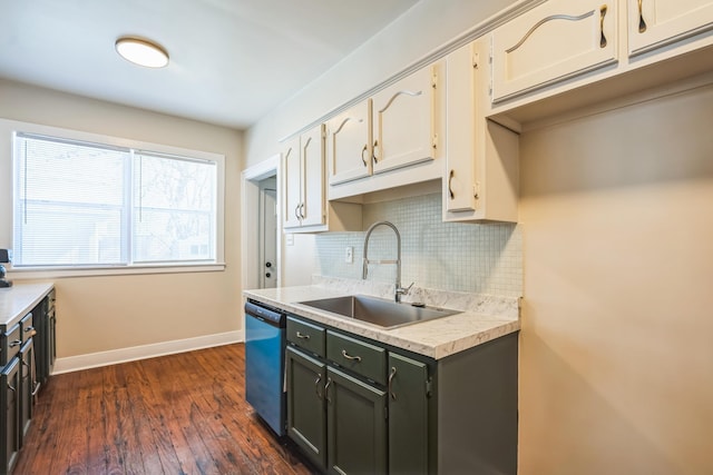 kitchen featuring baseboards, decorative backsplash, light countertops, stainless steel dishwasher, and a sink