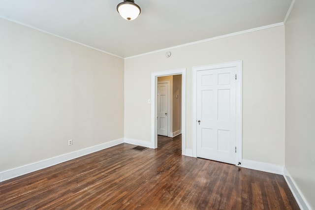 unfurnished bedroom with visible vents, baseboards, dark wood-type flooring, and crown molding