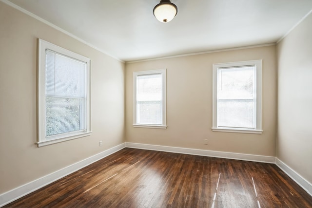 unfurnished room featuring ornamental molding, dark wood finished floors, and baseboards