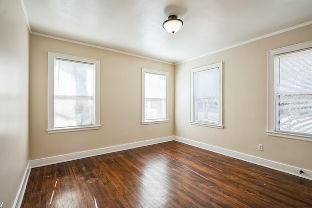 empty room featuring crown molding, dark wood finished floors, and baseboards