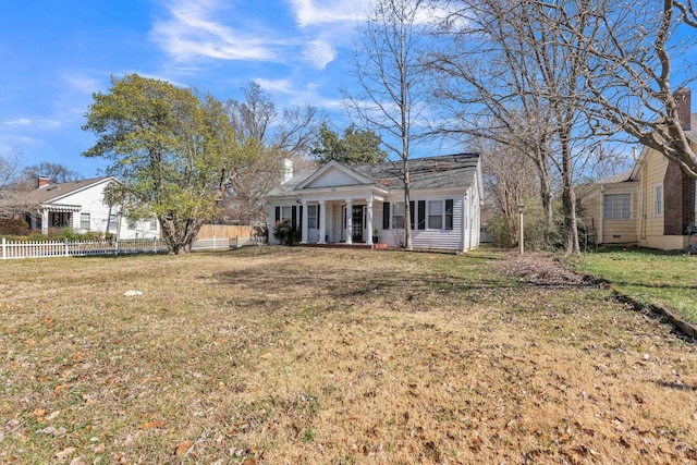 view of front of home featuring covered porch, fence, and a front yard