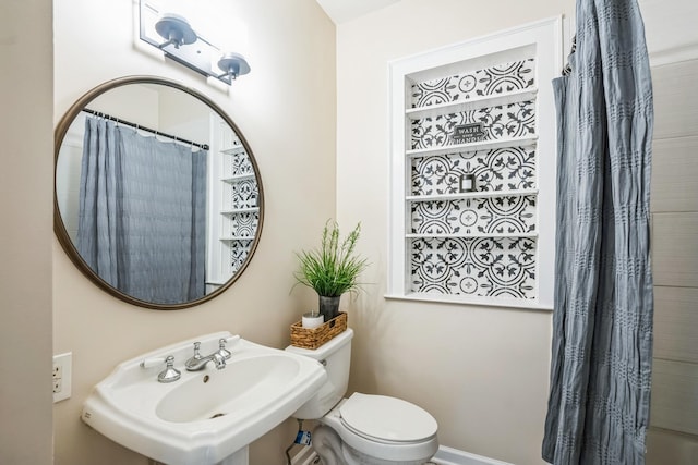 bathroom with a shower with curtain, a sink, and toilet