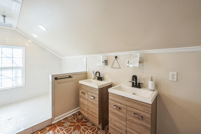 full bathroom featuring lofted ceiling, two vanities, a sink, and a walk in shower