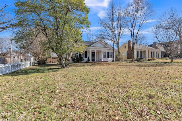 view of front facade featuring a front yard and fence