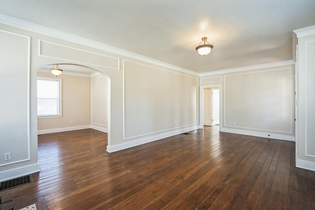 empty room featuring dark wood-style floors, arched walkways, visible vents, and ornamental molding