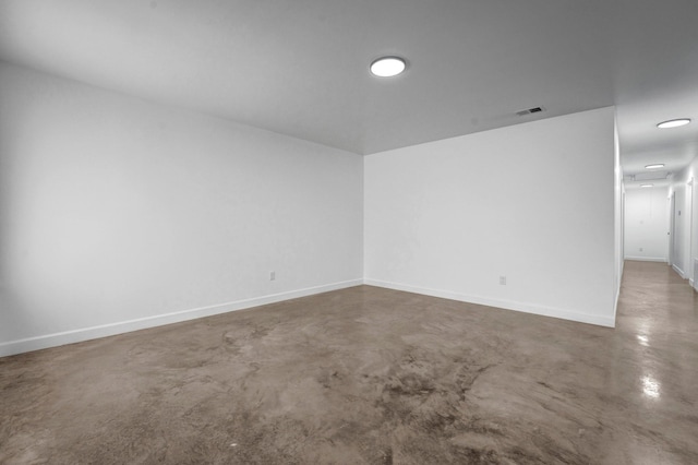 unfurnished room with concrete flooring, visible vents, and baseboards