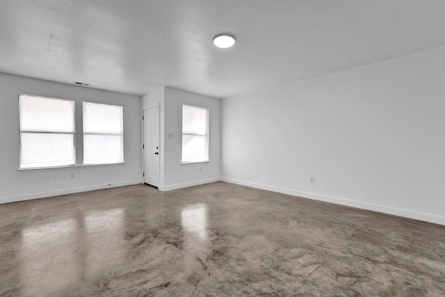 empty room featuring visible vents, concrete floors, and baseboards