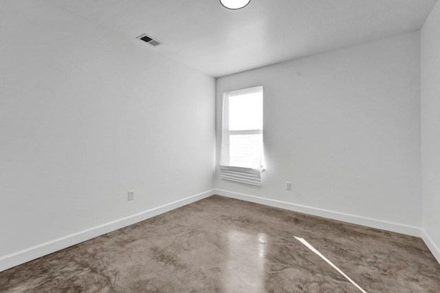 unfurnished room featuring visible vents, finished concrete flooring, and baseboards