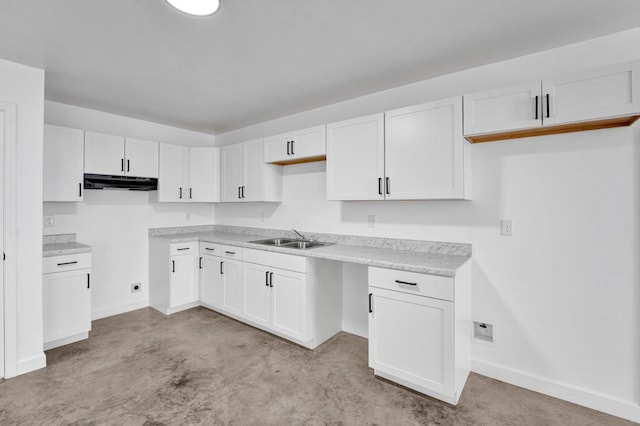 kitchen with a sink, light countertops, under cabinet range hood, and white cabinets