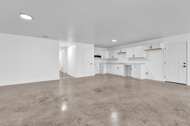 unfurnished living room with concrete floors, recessed lighting, and baseboards