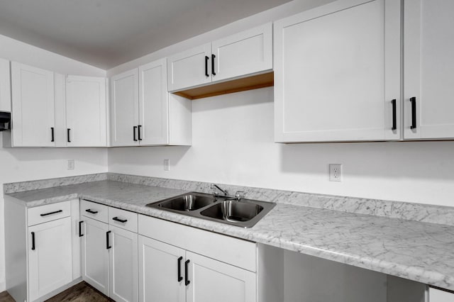 kitchen featuring white cabinetry and a sink