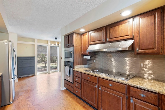 kitchen featuring under cabinet range hood, stainless steel appliances, decorative backsplash, and light wood finished floors