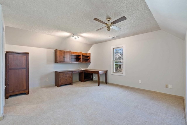 office space featuring light carpet, visible vents, baseboards, ceiling fan, and vaulted ceiling