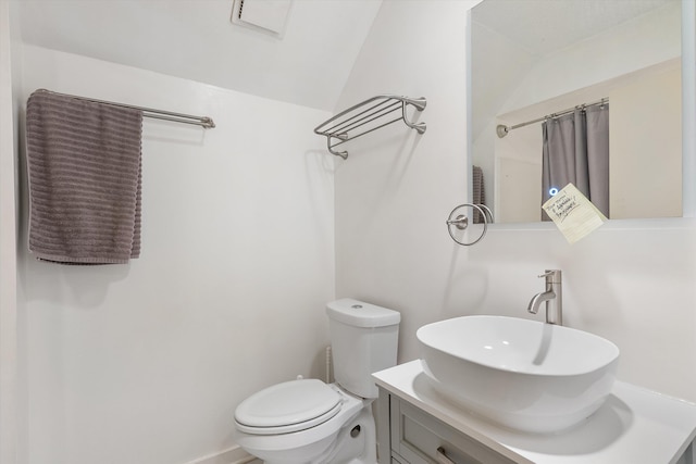 bathroom featuring toilet, a shower with curtain, vaulted ceiling, and vanity