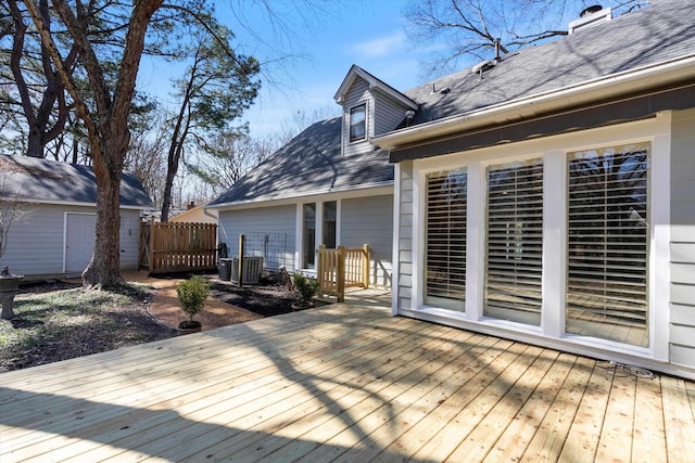 wooden deck featuring an outbuilding and central AC