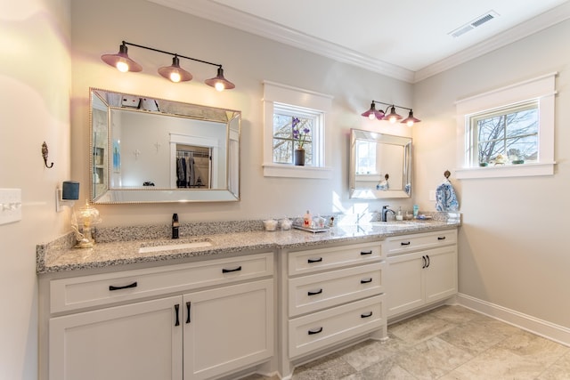 full bath featuring double vanity, crown molding, visible vents, and a sink