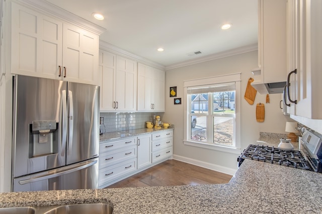 kitchen featuring appliances with stainless steel finishes, light stone counters, and white cabinets