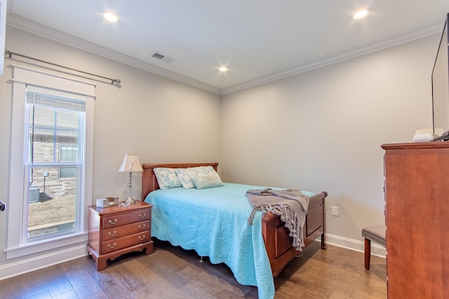 bedroom featuring baseboards, visible vents, dark wood finished floors, and crown molding