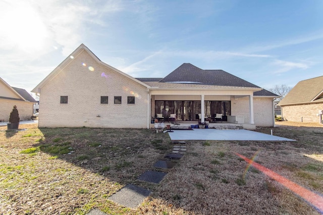 back of property with a patio area and brick siding