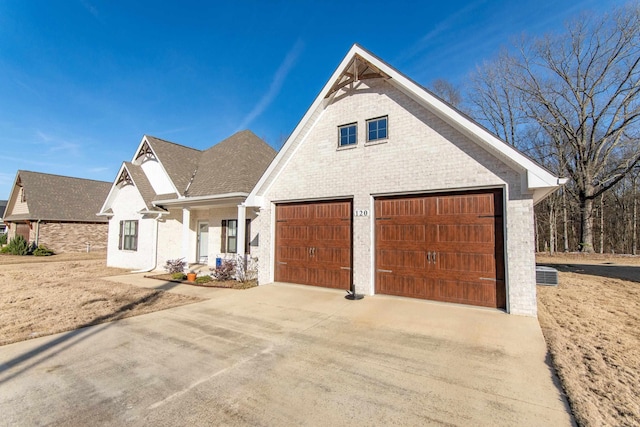 view of front of property with driveway, a shingled roof, and brick siding