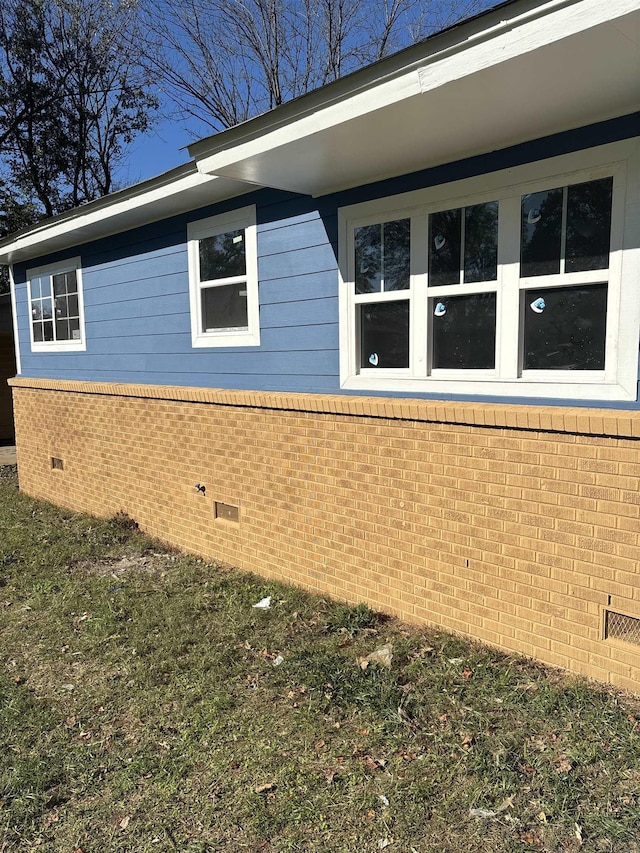 view of side of property featuring crawl space and brick siding